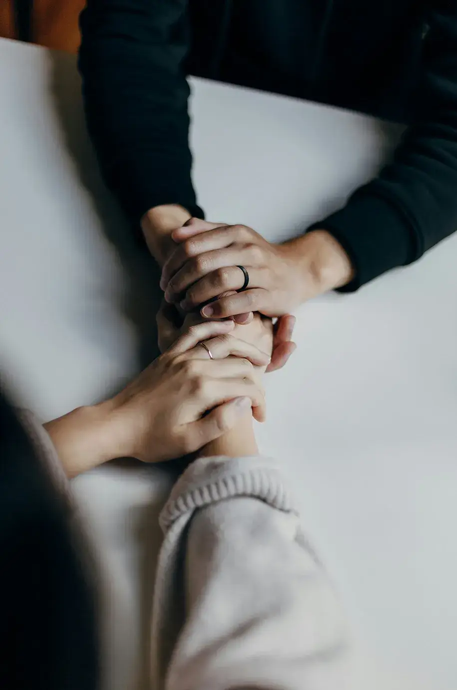 Two people holding hands across table